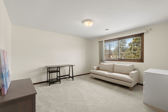 sitting room featuring light colored carpet and baseboards