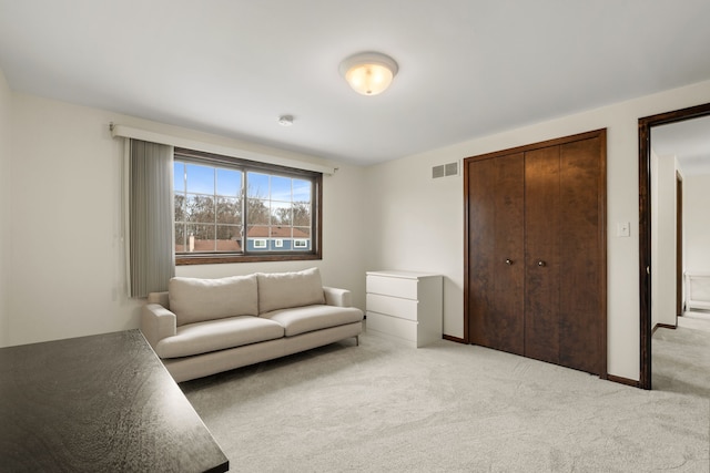 sitting room with visible vents, light carpet, and baseboards