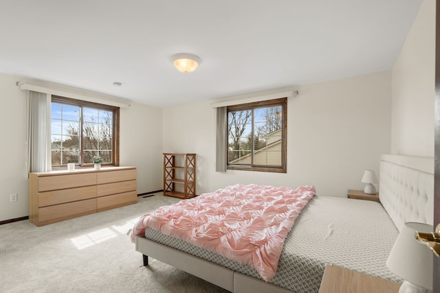 bedroom with baseboards and light carpet