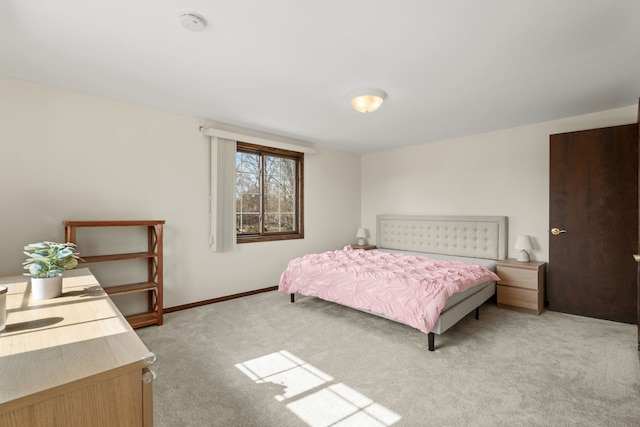 bedroom featuring light carpet and baseboards