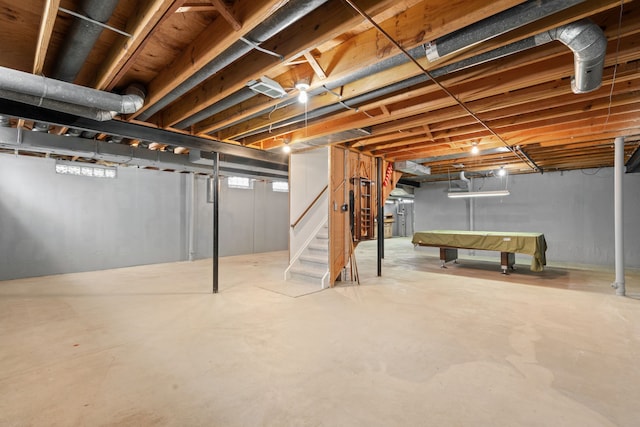 unfinished basement with pool table and stairs