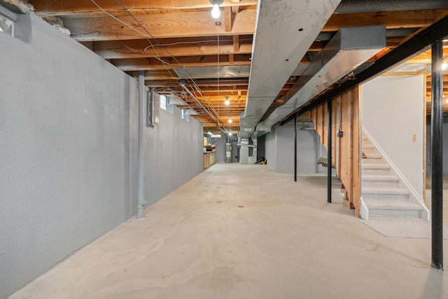 unfinished basement with stairway and water heater