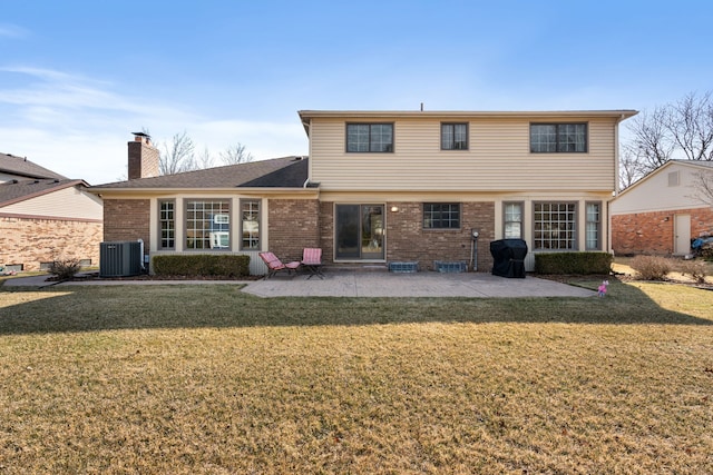 rear view of property featuring brick siding, a patio area, central AC unit, and a yard