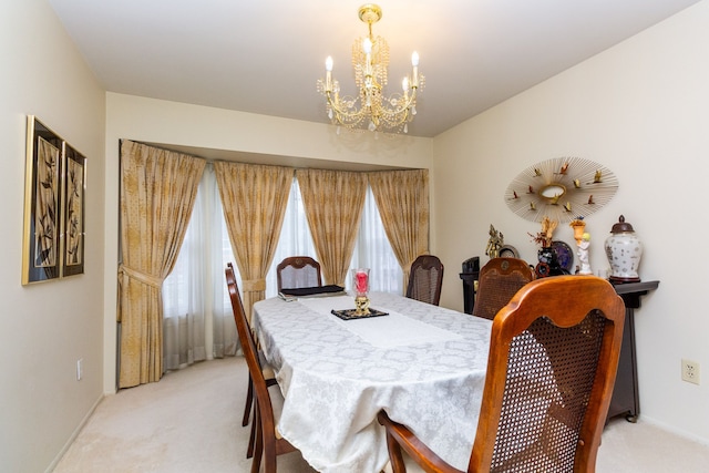 dining space featuring baseboards, light colored carpet, an inviting chandelier, and a healthy amount of sunlight