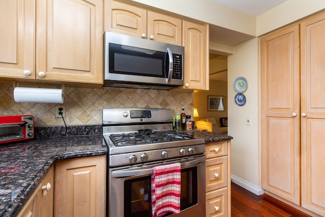 kitchen with dark wood finished floors, light brown cabinets, tasteful backsplash, and stainless steel appliances