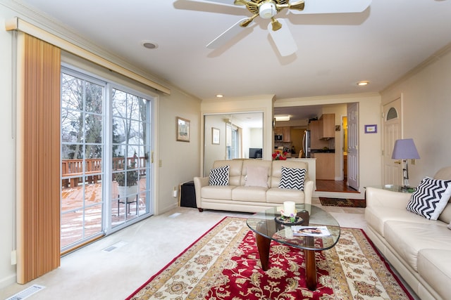 living room with recessed lighting, visible vents, light carpet, and ornamental molding