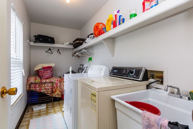 laundry room featuring laundry area, light floors, a sink, and separate washer and dryer