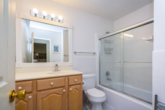 full bathroom featuring bath / shower combo with glass door, toilet, and vanity