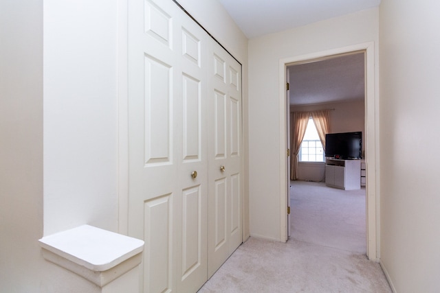 hall featuring light carpet and baseboards