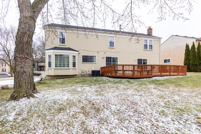 rear view of property with a chimney and a deck