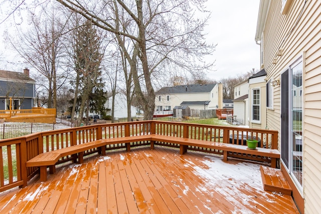 snow covered deck featuring fence and a residential view