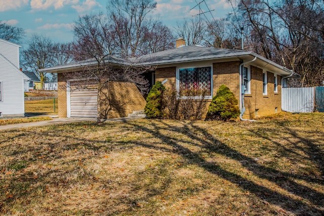 ranch-style house featuring fence, an attached garage, a chimney, a front lawn, and brick siding