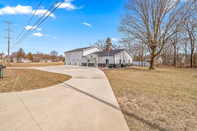 view of front of house featuring concrete driveway and a front lawn