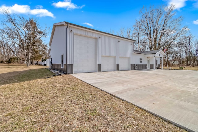 view of side of property featuring a yard and concrete driveway