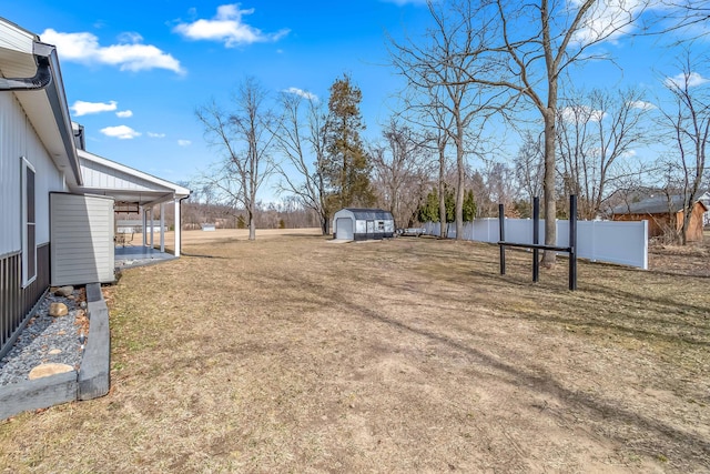 view of yard featuring an outbuilding, a storage unit, and fence