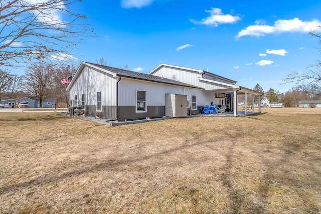 rear view of property featuring a lawn and a patio