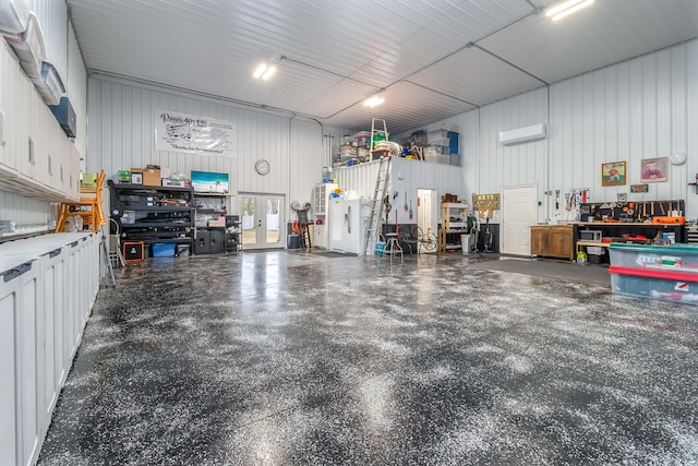 garage featuring a workshop area, metal wall, and a wall mounted AC