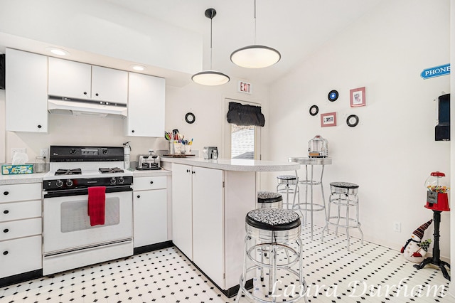 kitchen with under cabinet range hood, light countertops, white gas range, a peninsula, and white cabinetry