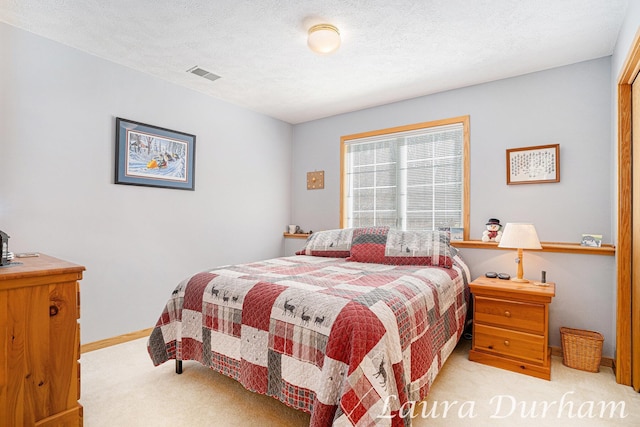 bedroom with visible vents, a textured ceiling, baseboards, and carpet floors