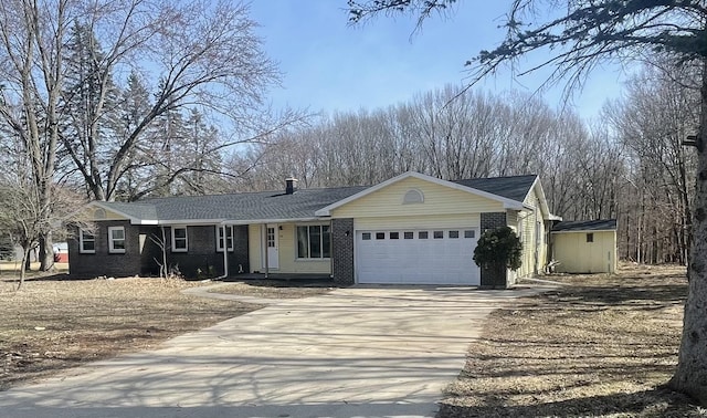 ranch-style home featuring an outdoor structure, brick siding, a garage, and driveway