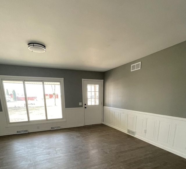 interior space featuring visible vents and wainscoting