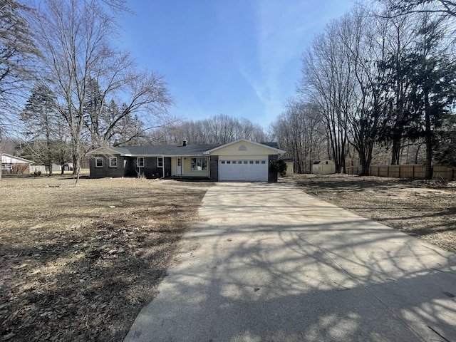 ranch-style house featuring driveway, a garage, and fence