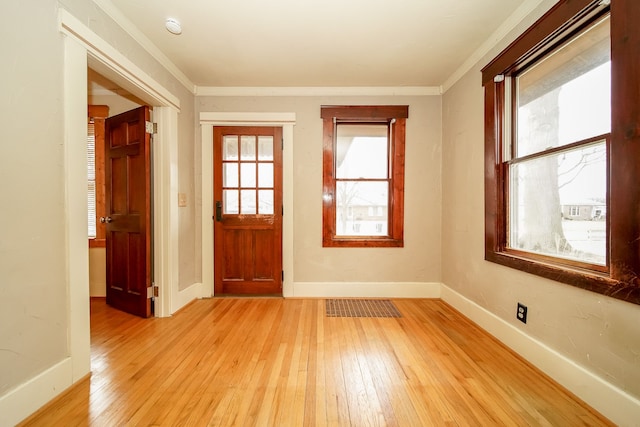 entrance foyer featuring light wood-style flooring, visible vents, baseboards, and ornamental molding