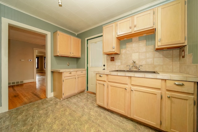 kitchen with a sink, visible vents, tile countertops, and light brown cabinetry