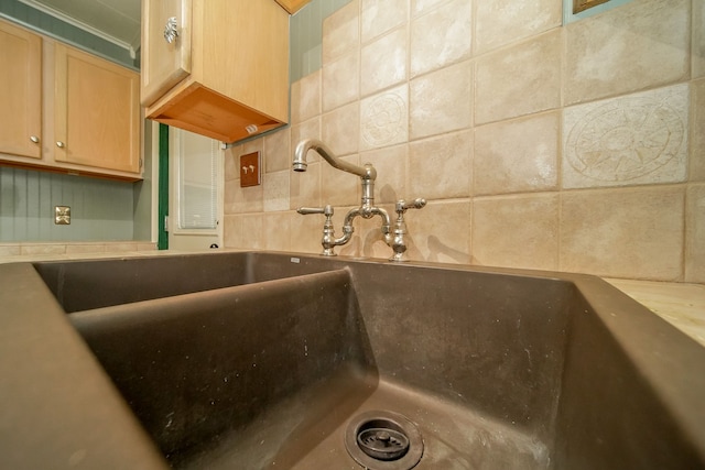 room details featuring ornamental molding, tasteful backsplash, light brown cabinetry, and a sink