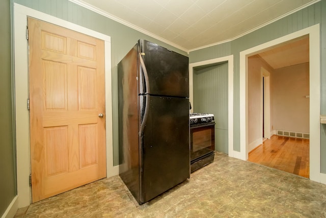 kitchen with range with gas cooktop, crown molding, visible vents, and freestanding refrigerator