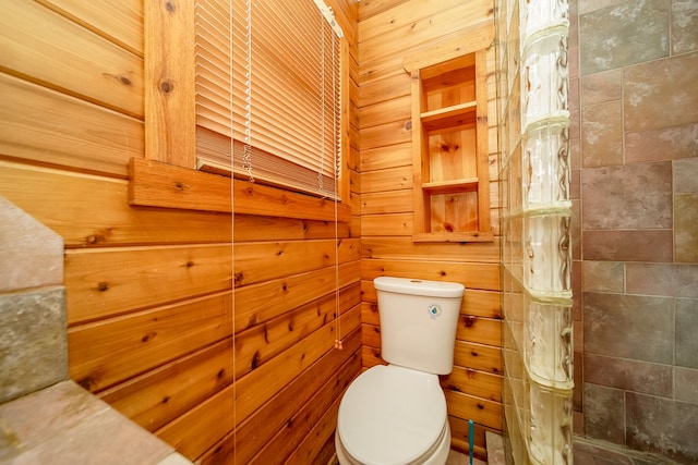 bathroom featuring tiled shower and toilet