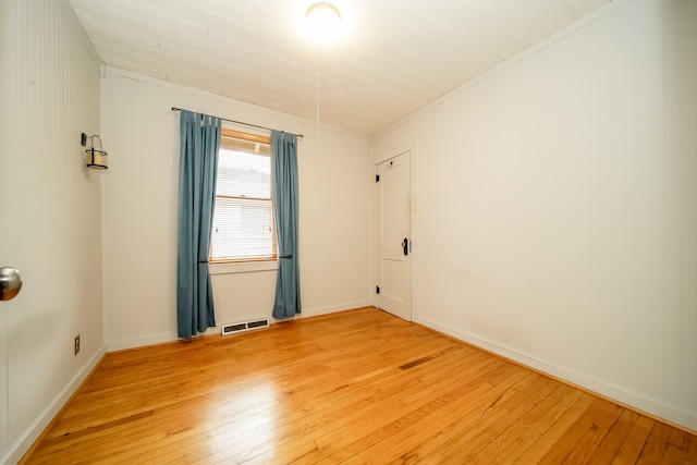 unfurnished room with crown molding, baseboards, visible vents, and light wood finished floors