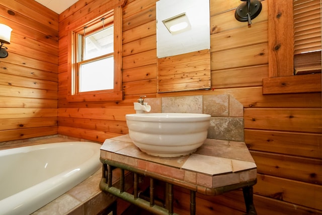 full bath featuring a garden tub, wood walls, and vanity