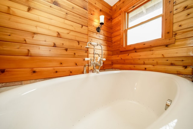 interior space featuring a tub and wooden walls