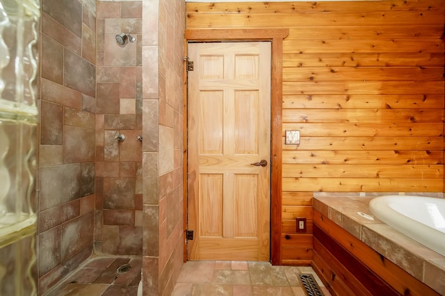 bathroom featuring stone finish floor, tiled shower, and vanity