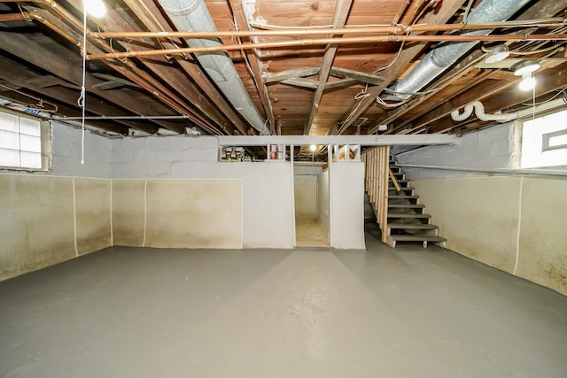 basement featuring plenty of natural light and stairs