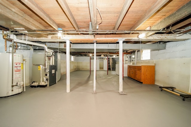 basement with heating unit, gas water heater, and washer / clothes dryer