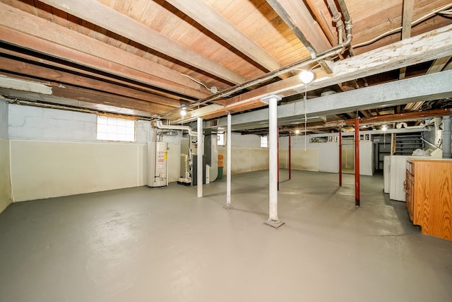 basement with gas water heater, heating unit, and separate washer and dryer