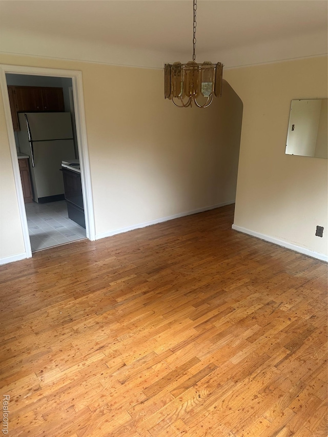 3389 Beaumont Rd, Ann Arbor, MI 48105 - empty room featuring a chandelier, light wood-style flooring, and baseboards
