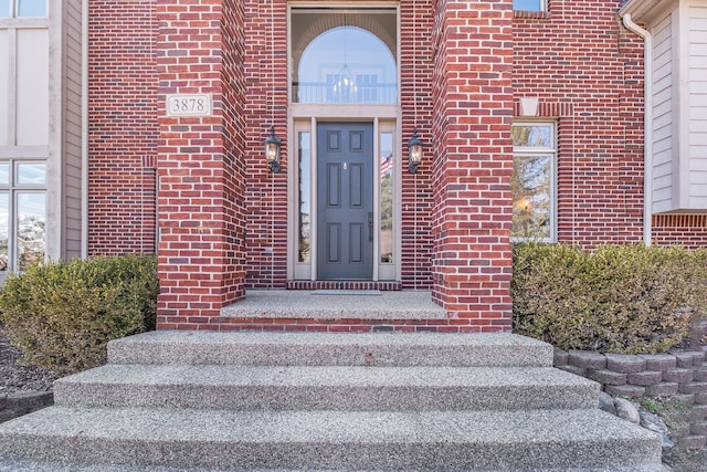 doorway to property featuring brick siding