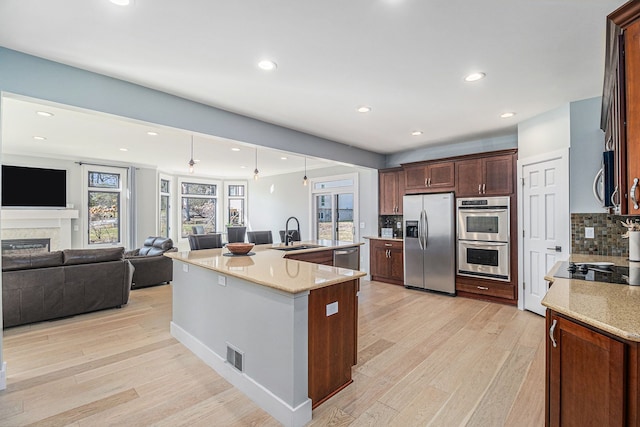 kitchen featuring a sink, visible vents, light wood finished floors, and stainless steel appliances