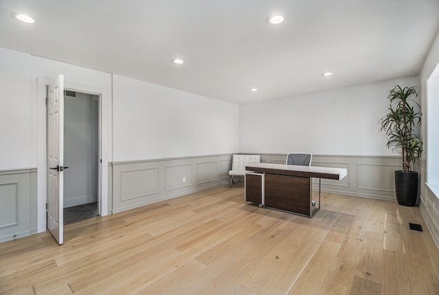 office area featuring recessed lighting, light wood-type flooring, and a decorative wall