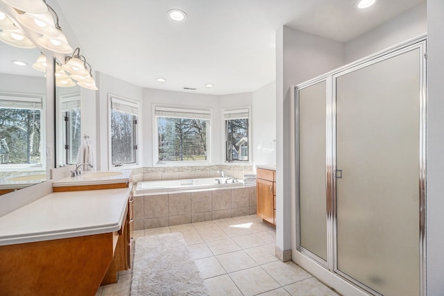 full bathroom with tile patterned floors, a garden tub, a healthy amount of sunlight, and a shower stall