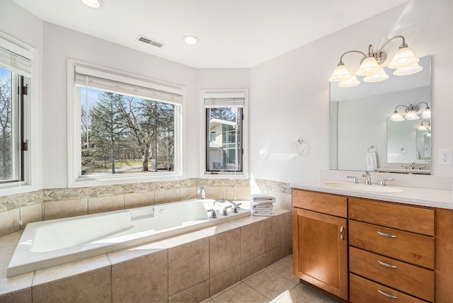 full bath with tile patterned flooring, a garden tub, vanity, and visible vents