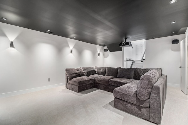 home theater featuring baseboards and light carpet