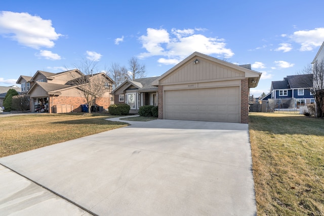 view of front of house featuring a front lawn, brick siding, and driveway