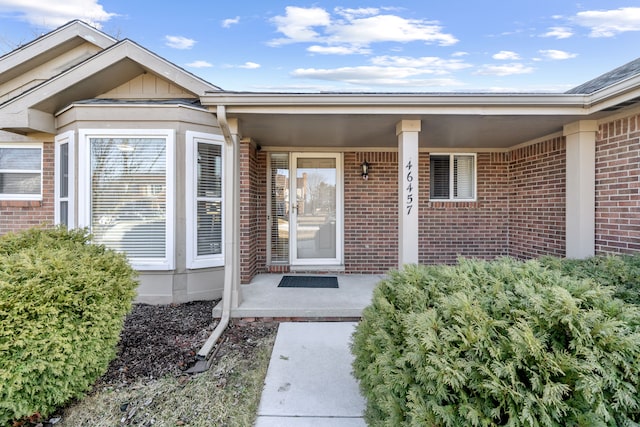 view of exterior entry with brick siding and board and batten siding