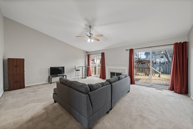 living area with carpet flooring, a fireplace, ceiling fan, and vaulted ceiling