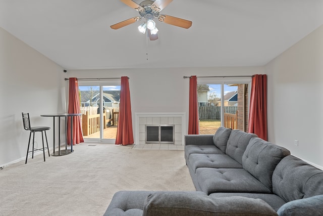 carpeted living area with a wealth of natural light, ceiling fan, a fireplace, and baseboards