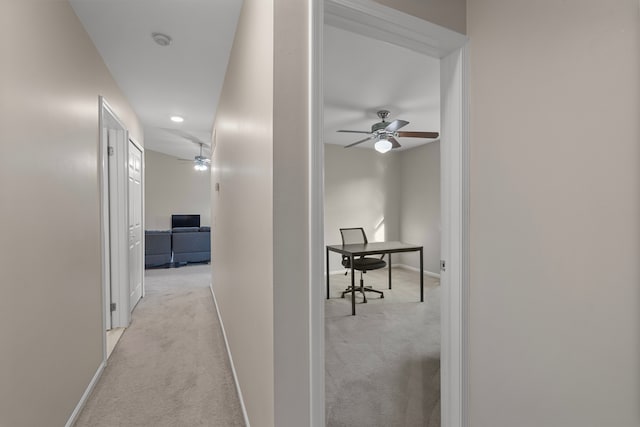 corridor with baseboards and carpet flooring